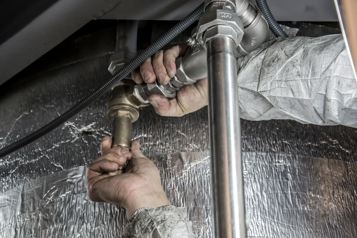 Sierra Heating and Cooling HVAC technician inspecting a residential air conditioning condenser unit in Houston, Texas